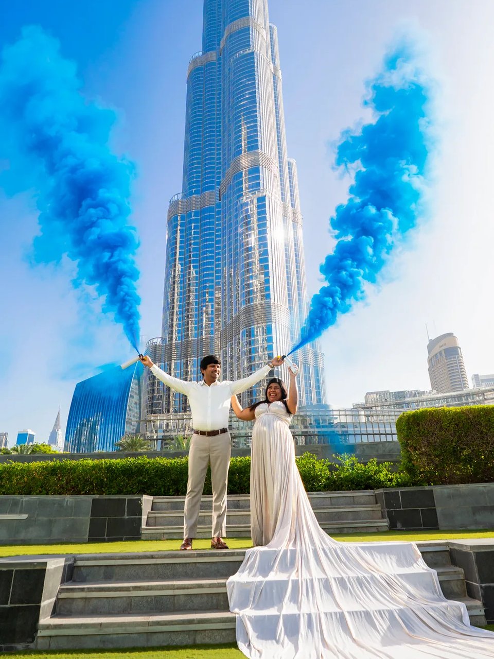 Gender reveal photoshoot in a white flying dress with the Burj Khalifa behind