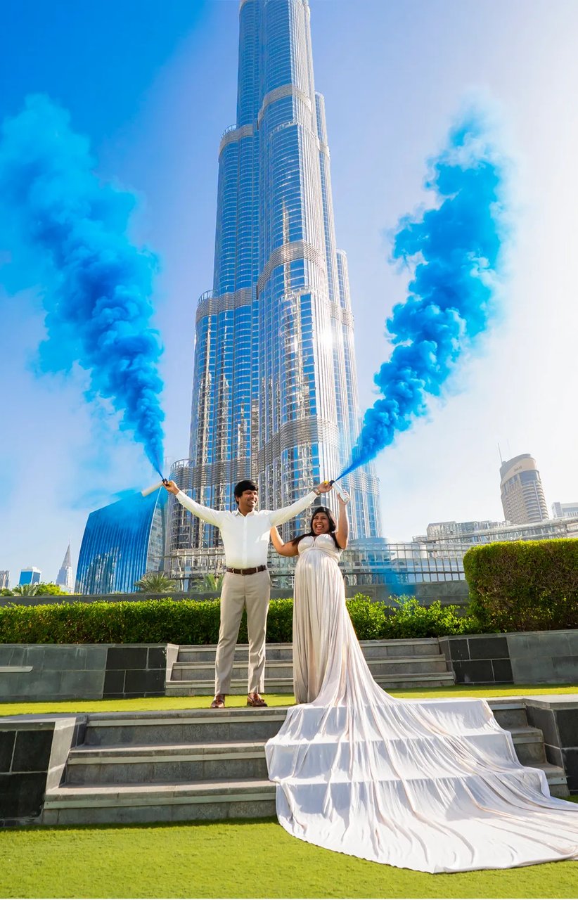 Gender reveal photoshoot in a white flying dress with the Burj Khalifa behind
